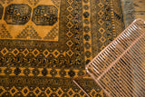Detail of a vintage Daulatabad rug's thick pile, saffron field, and navy elephant footprint guls.