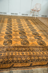Low angle view of a vintage Daulatabad rug showing rows of navy elephant footprint gul motifs.
