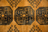 Elephant footprint gul motif in dark navy on a thick saffron yellow wool pile.
