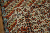 Tribal animal, human, and starburst motifs on ivory field with vivid striped border of Daghestan rug.