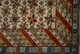 Geometric starbursts, striped border, and powder blue edge of a Vintage Daghestan rug.