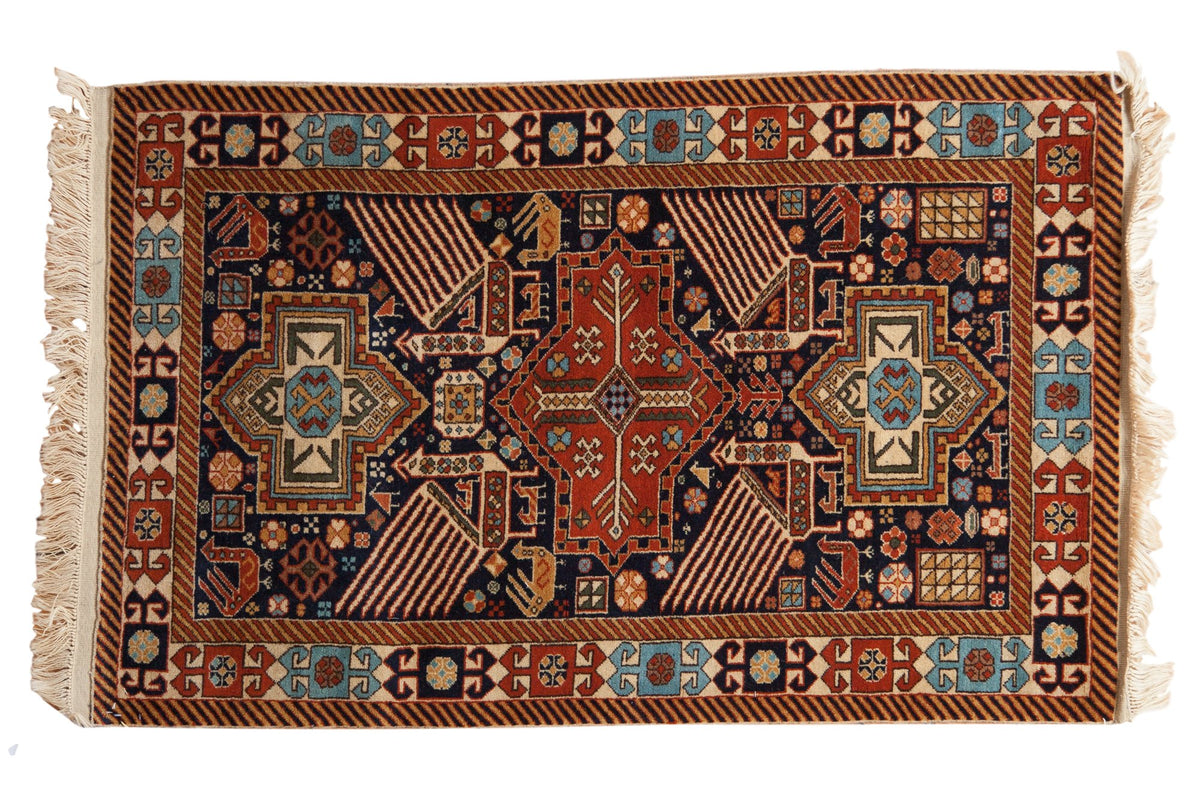 Vintage Romanian Akstafa rug with a triple center medallion and large birds on a navy blue ground.