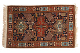 Vintage Romanian Akstafa rug with a triple center medallion and large birds on a navy blue ground.