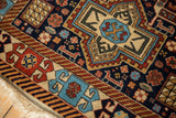 Close-up of a vintage rug's corner showing detailed geometric motifs and intact selvage.