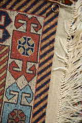 Intact original side cord selvage and ivory fringe on a vintage Romanian geometric rug.