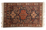 Vintage Romanian Akstafa rug with triple center medallions and geometric birds on a navy blue field.