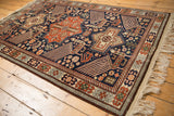 Vintage Romanian rug with geometric bird motifs and medallions in rust, sand, and navy blue.