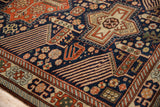 Detail of the hand-knotted pile showing geometric birds with finned feathers in rust and navy.