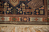 Geometric border, bird motifs, and hand-knotted ivory fringe on a vintage Romanian rug corner.