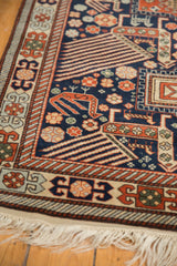 Corner of a Romanian Akstafa rug with geometric bird motifs, intricate borders, and ivory fringe.
