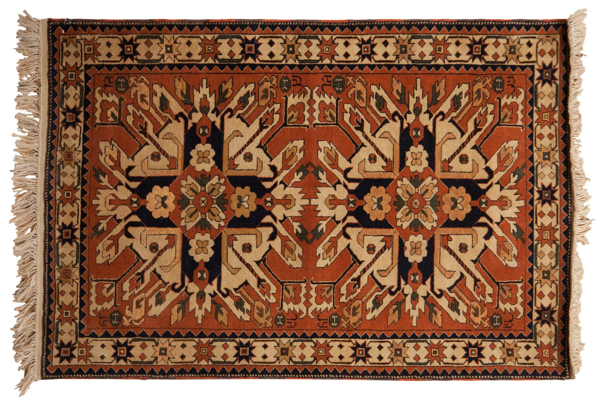 Vintage Romanian Kazak rug with double starburst medallions in rust, navy blue, and ivory tones.