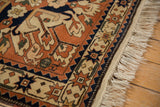 Close-up of the Kazak rug's starburst border, intact side cord selvage, and original fringe.