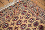 Intricate geometric borders and clean ivory fringe on a vintage Pakistani Bokhara rug with a plush golden pile.