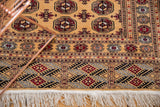 Intricate finned guls border and ivory fringe on a golden vintage Bokhara design rug.