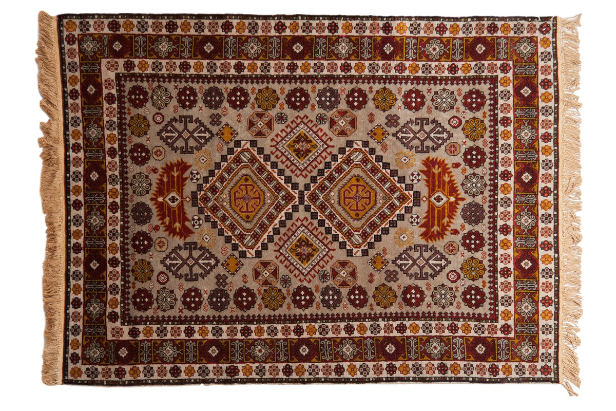Vintage Romanian Shirvan rug with a double diamond medallion in rust and gold on a silver geometric field.