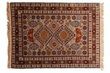 Vintage Romanian Shirvan rug with a double diamond medallion in rust and gold on a silver geometric field.