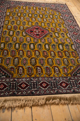 Plush golden wool pile of a vintage Romanian rug, showing the intricate boteh pattern and fringe.