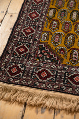 Corner detail of a vintage rug showing its intricate geometric border and intact side cord selvage.