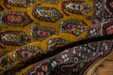 Folded view highlighting the plush, deep gold wool pile of the vintage Shirvan design rug.