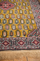 Plush gold wool pile with boteh motifs beside a raspberry red geometric border and neat fringe.