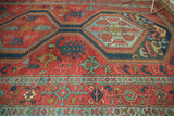 Geometric motifs in powder blue and oxidized green within the paneled medallions of a collector Serapi rug.