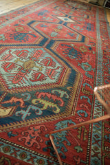 Angled view down the length of a collector's antique Serapi runner, showing its bold geometric medallions.