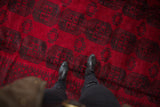 Repeating charcoal Bokhara gul medallions on the full, cherry red pile of an Ersari rug.