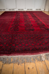 Angled view across the plush, deep red pile and natural wool fringe of an Ersari carpet.