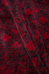 Plush, full pile texture of a hand-knotted Ersari rug in saturated cherry red and charcoal.