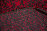 Intact side cord and hand-knotted foundation of a red and charcoal vintage Afghani carpet.