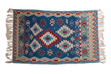 Vintage Turkish Kilim rug, geometric multi-medallion and wave motif on a denim blue field.