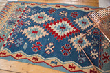 Vintage Turkish Kilim rug, denim blue field with cherry red floral and wave patterns.