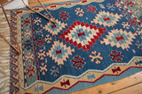 Denim blue, red, and sand floral and wave patterns on a vintage Turkish Kilim.