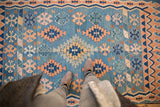 Turkish Kilim with sky blue, apricot, ivory, and mallard green geometric patterns.