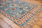 Vintage Turkish Kilim rug, with abrashed sky blue field, apricot running wave border, and ivory fringe.