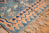 Vintage Turkish Kilim rug featuring running wave and geometric motifs in sky blue and apricot.