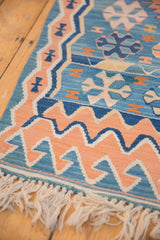 Sky blue and apricot running wave motif with ivory fringe on Turkish Kilim rug.