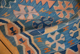 Apricot vine and running wave motifs on a sky blue vintage Turkish Kilim rug.