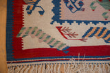 Hand woven Turkish Kilim corner with fringe, red border, and pictorial bird and plant motifs.