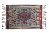 Vintage Turkish Kilim rug with a red and blue geometric medallion, ram's horn motifs, and abrashes on a powder blue field.
