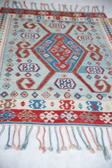 Serrated medallion and geometric ram's horn motifs in red and blue on a fine Turkish Kilim.