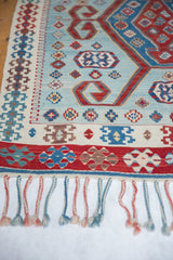 Layered geometric border with rams horn motifs and knotted fringe on a vintage Turkish Kilim.