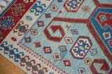 Serrated red and blue rams horn motifs on the powder blue abrash field of a vintage Kilim.