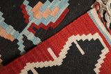 Hand woven Turkish Kilim rug detail with stepped geometric patterns in charcoal, red, and blue.