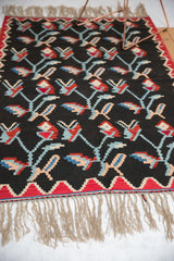 Hand woven Turkish Kilim rug's natural fringes and red zig-zag border with apricot blush accents.
