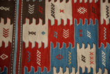 Detail of hand-woven Turkish Kilim showing red, sky blue, ivory paneled finned motifs and snowflakes.