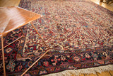 Vintage Mehrivan carpet with a dense floral pattern and navy border viewed from a corner angle.