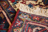 Corner of a vintage Mehrivan carpet showing its original red side cord and ivory fringe.