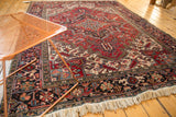 Vintage Heriz carpet corner showing the detailed navy border and madder red geometric field.