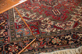 Serrated leaf and floral motifs on the even pile of a vintage Heriz carpet.